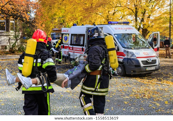 Firefighters deliver the injured person to\
paramedics during fire training at a local school in Uzhgorod,\
Ukraine - November 12,\
2019.