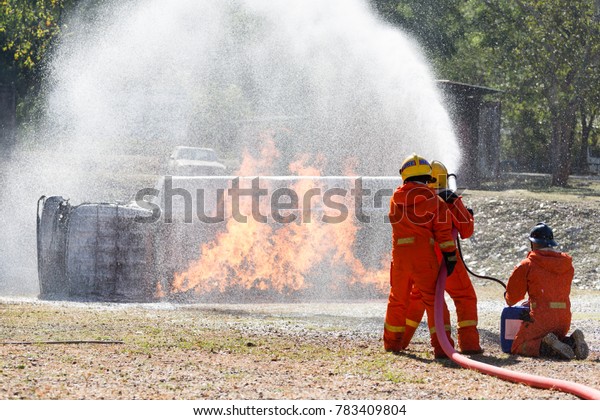 Firefighters extinguish the\
fire with a chemical hose foam coming from the fire engine Through\
Fire Hose Coil / Fire on burning car lpg ngv Gas-powered vehicles -\
Help
