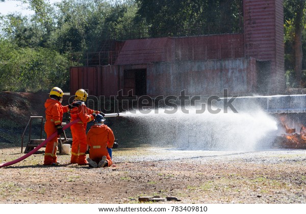 Firefighters extinguish the\
fire with a chemical hose foam coming from the fire engine Through\
Fire Hose Coil / Fire on burning car lpg ngv Gas-powered vehicles -\
Help