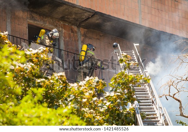 firefighters extinguish a fire in a high-rise\
residential\
building