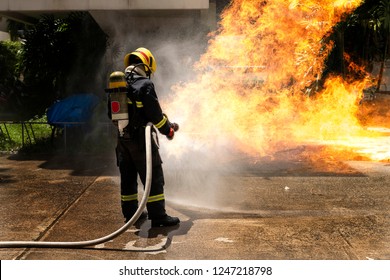 Firefighters With Extinguisher Spraying High Pressure Water To Fighting The Fire Flame In An Emergency Situation.