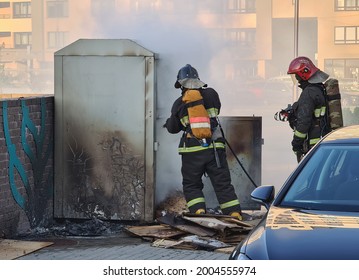 Firefighters Extinguishing Garbage Can Fire In Car Park