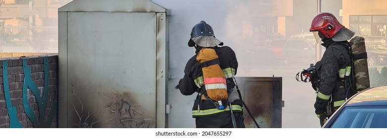 Firefighters Extinguishing Garbage Can Fire In Car Park