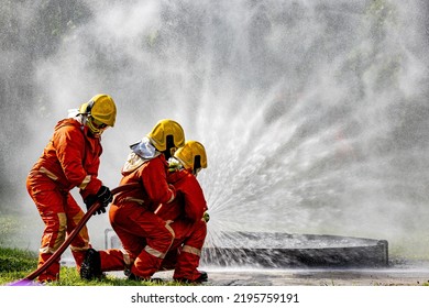 Firefighters, Firemen spraying high pressure water or suitable extinguishing agents to fire.fire fighter Using Twirl water mist fire extinguishers to fight oil flames to control fires from spreading.