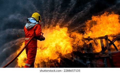 Bomberos, bomberos rociando agua a alta presión o agentes extinguidores adecuados para disparar. Bomberos usando extinguidores de incendios de bruma de agua para combatir las llamas del petróleo para controlar la propagación de incendios.