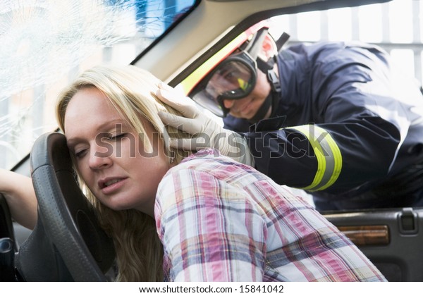 Firefighters helping an\
injured woman in a\
car