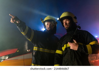 Firefighters Men At Action With Fire Truck In Background At Night