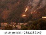 Firefighters monitor the Franklin Fire as flames and smoke billow in Malibu, California, during a fierce wildfire, showcasing their heroic efforts in managing the disaster.