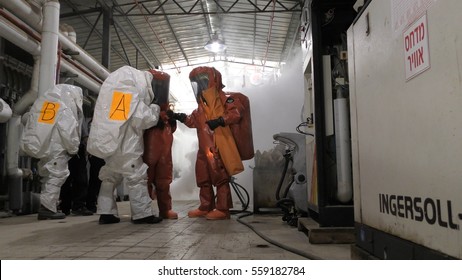 Firefighters Practice Sealing Of Leak Accident From Corrosive Toxic Hazardous Material Ammonia Liquid Container In Fruit Factory Dressing Protective Suites, Yesud Hamaala, Israel, March 21, 2016.