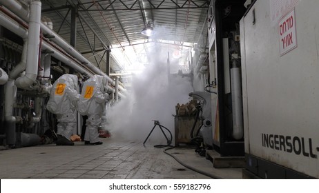 Firefighters Practice Sealing Of Leak Accident From Corrosive Toxic Hazardous Material Ammonia Liquid Container In Fruit Factory Dressing Protective Suites, Yesud Hamaala, Israel, March 21, 2016.