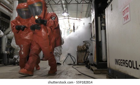 Firefighters Practice Sealing Of Leak Accident From Corrosive Toxic Hazardous Material Ammonia Liquid Container In Fruit Factory Dressing Protective Suites, Yesud Hamaala, Israel, March 21, 2016.