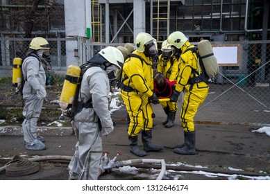 Firefighters And Rescuers In A Radiation Protection, Chemical Protection Suit  Rescue The Injured.