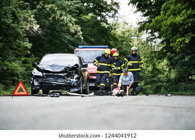 Firefighters Running To Rescue A Woman Lying Unconscious On The Road After A Car Accident.