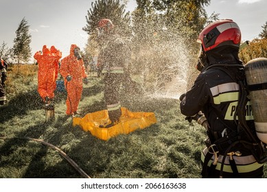 Firefighters Spray Water On Signs Of A Hot Zone, Chemical Danger, Elimination Of Extreme Temperature. Firefighter Rescuer - A Courageous Profession.