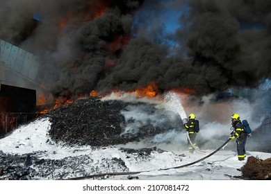 Firefighters use foam to extinguish a massive fire of large amounts of plastic waste
