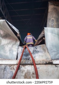 Firefighters Using Water Fog Fire Extinguisher To Fighting With The Fire Flame In Large Building. Firefighter And Industrial Safety Disaster And Public Service Concept.