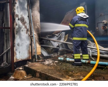 Firefighters Using Water Fog Fire Extinguisher To Fighting With The Fire Flame In Large Building. Firefighter And Industrial Safety Disaster And Public Service Concept.