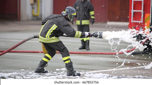 Feuerwehrleute beim Löschen des Brandes mit einer speziellen Feuerlöschausrüstung mit Formhom
