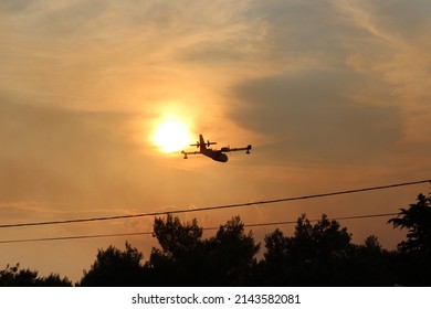 Firefighting Aircraft Over A Smoky Sunset