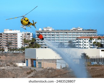 Firefighting with fire brigade helicopter using extinguishing water in Gran Canaria.