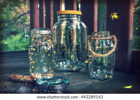 Fireflies in jars in a tree house, with magnifying glass. Long exposure, focus on top of jar on the left