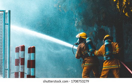 Fireman  attacking a fire with water. firefighter team work.