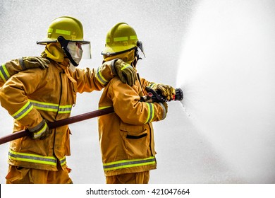 Fireman  attacking a fire with water. firefighter team work.