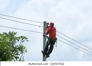 A Fireman Is Climbing On A Light Pole. To Install The Illumination.