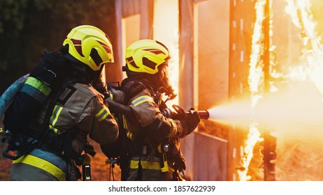 Fireman extinguish fire with the hose. Burning house fire drill. High quality photo
