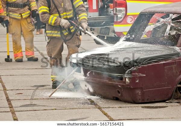 The fireman extinguishes the\
burned car. Training firefighters. Demonstration rescue\
work.