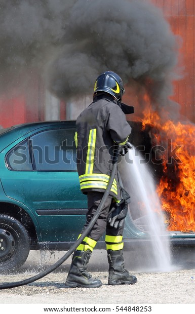 fireman extinguishes the fire of a car with foam\
after car accident