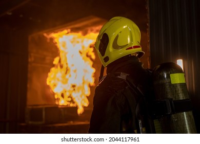 Fireman Extinguishes A Fire,Firefighter Water Spray By High Pressure Fire Hose In An Emergency Situation.