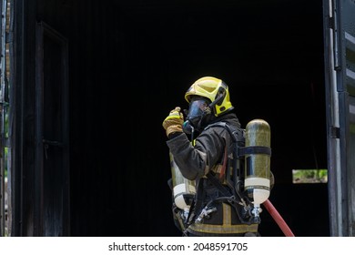 Fireman Extinguishes A Fire,Firefighter Water Spray By High Pressure Fire Hose In An Emergency Situation.