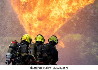 Fireman Extinguishes A Fire,Firefighter Water Spray By High Pressure Fire Hose In An Emergency Situation.