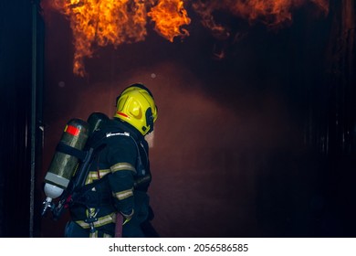 Fireman Extinguishes A Fire,Firefighter Water Spray By High Pressure Fire Hose In An Emergency Situation.