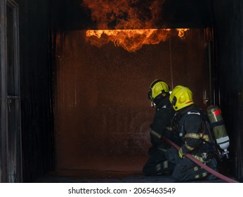 Fireman Extinguishes A Fire,Firefighter Water Spray By High Pressure Fire Hose In An Emergency Situation.