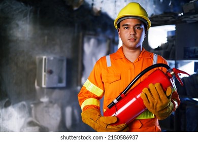Fireman hand holding fire extinguisher. available in emergencies conflagration damage background. Safety concept. - Shutterstock ID 2150586937