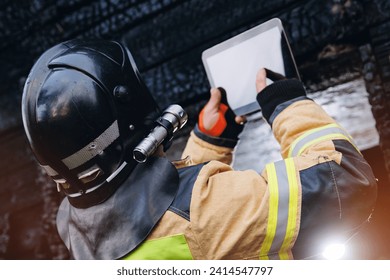 Fireman inspector officer inspects burnt house, take photo on tablet for report of investigating incident fire. Control safety after burning apartment.