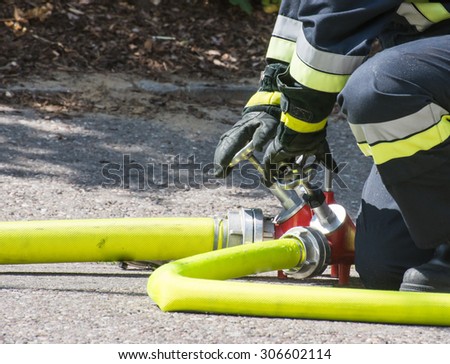 Fireman operating the valve of a firehose