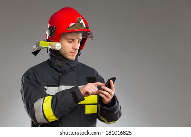 Fireman Using Smart Phone. Waist Up Studio Shot Isolated On White.