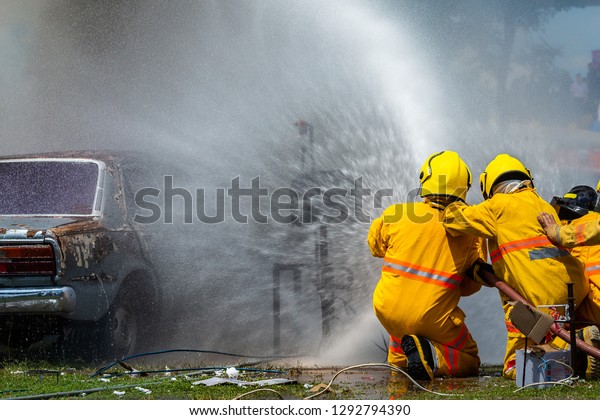 fireman using water and extinguisher car is on\
fire,Firefighter using extinguisher and water from hose for fire\
fighting,burning car\
Gas.