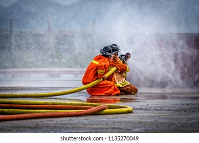 Fireman using water and extinguisher to fighting with fire flame in an emergency situation Car crash .under danger situation all firemen wearing suit for safety.