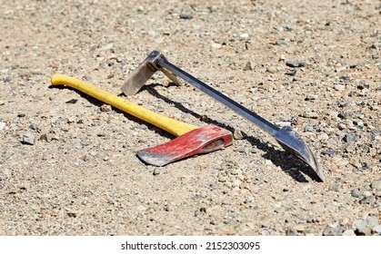 Fireman's forceable entry tools, a halligan and an axe laying on the ground