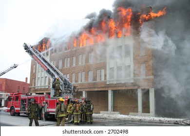 Firemen Fighting A Fire In A Large Apartment Building