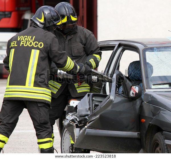 firemen open the door of the car with a powerful\
pneumatic shears