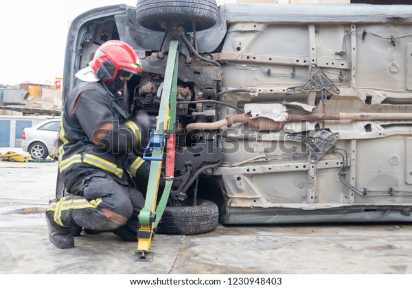 Firemen practicing techniques of rescue of\
victims in traffic accidents with\
tools