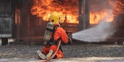 Firemen Use Extinguisher Water Fight Fire Burn During Firefight Training. Firefighter Wearing Fire Suit For Safety Danger Situation. Fireman Work Closely With Other Emergency Response Agency