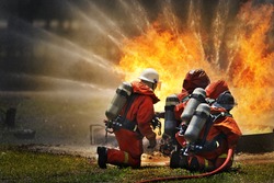Firemen Using Extinguisher And Water For Fight Fire During Firefight Training. All Fighter Wearing Fire Suit For Safety Under Danger Situation.Fireman Work Closely With Other Emergency Response Agency