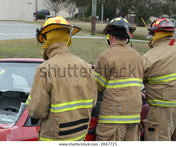 Firemen working at a wreck\
scene.