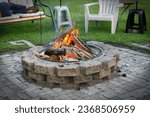 Firepit. Bonfire. Flames. Outdoor living. Leisure. Backyard. Trailer. Lawn chairs. Logs. Wood. Summer. Summertime. Get together. Friends. Bricks. Campfire. Green grass. 